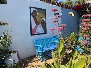 a blue bench next to a wall with a painting at The Mango Guest House in Aswan