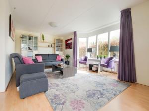 a living room with a couch and a chair at Vacation home with Jacuzzi in Schoonloo