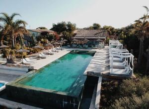 una gran piscina con sillas y un puente blanco en Finca Hotel Rural Es Turó, en Ses Salines