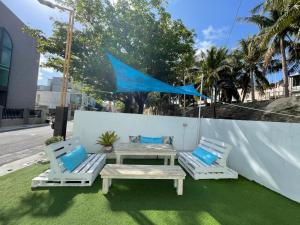 a patio with two chairs and a table and a blue umbrella at 恆春洋蔥風格旅居 onion in in Hengchun