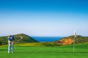a man is playing golf on a golf course at Sunshine Koutouloufari in Hersonissos