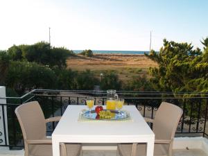 a table with a plate of fruit and juice on a balcony at Lazaris Apartments in Agios Ioannis Lefkada in Lefkada