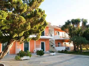 a large building with trees in front of it at Lazaris Apartments in Agios Ioannis Lefkada in Lefkada