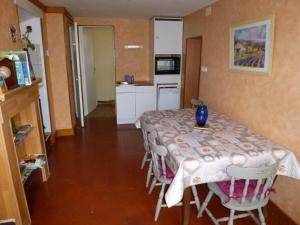 a room with a table with chairs and a kitchen at Gîte familial avec jardin, terrasse, vélos, Wifi, et animaux acceptés near Saint Pol sur Ternoise - FR-1-376-47 in Fiefs +3 photos