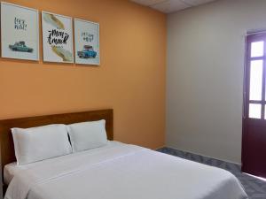 a bed in a room with pictures on the wall at Eden House & Coffee Con Dao in Con Dao