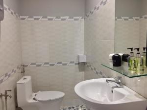 a white bathroom with a toilet and a sink at Eden House & Coffee Con Dao in Con Dao
