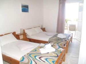 two twin beds in a room with a window at Lazaris Apartments in Agios Ioannis Lefkada in Lefkada
