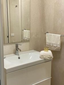 a bathroom with a white sink and a mirror at Panorama Apartment in Trieste