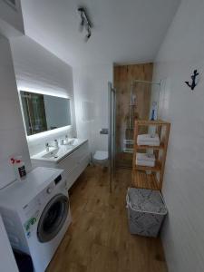 a bathroom with a washing machine and a sink at Apartment LILY - Baltic Park Pogorzelica in Pogorzelica