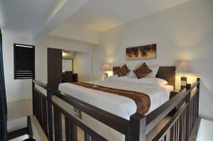 a bedroom with a large bed on a balcony at Ganga Hotel & Apartment in Denpasar +13 photos