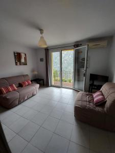 a living room with a couch and a large window at Résidence E CIME ASCO in Asco