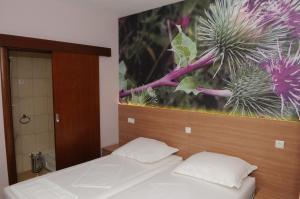ein Schlafzimmer mit 2 Betten und einem Wandgemälde in der Unterkunft Guest House Ostojić in Međugorje