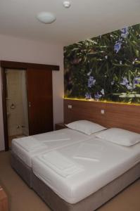 1 dormitorio con 1 cama con una pintura en la pared en Guest House Ostojić, en Međugorje