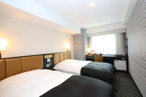 a hotel room with two beds and a window at APA Hotel Sugamo Ekimae in Tokyo