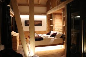 - une chambre avec un lit dans une pièce en bois dans l'établissement Hotel Ciasa Lorenzi, à Cortina dʼAmpezzo