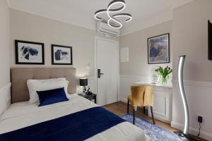 a bedroom with a blue and white bed and a desk at Classic Hotel by Athens Prime Hotels in Athens