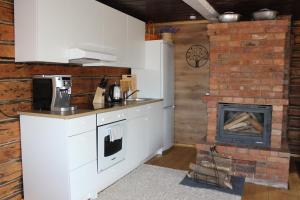 a kitchen with a stove and a brick fireplace at Lauku māja Latgalē - ''Siguldas'' 