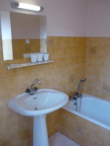 a bathroom with a sink and a bath tub at Le Miramont in Orincles