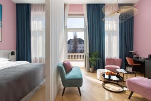 - une chambre avec un lit, une chaise et une fenêtre dans l'établissement Alice Hotel, à Budapest