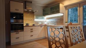 a kitchen with white cabinets and a stove top oven at Hoamatl, Appartement in Tux