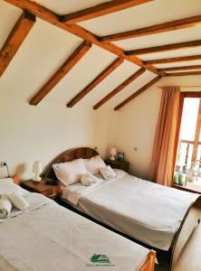 皮羅特的住宿－Villa Balconlux - Zavojsko jezero, Pirot，配有木天花板的客房设有两张床。