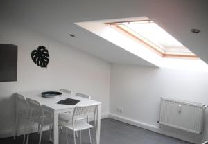 a dining room with a white table and a skylight at Work & Stay Apartments in Euskirchen in Euskirchen