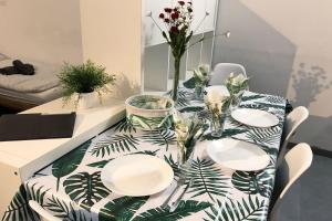 a dining room table with plates and flowers on it at Work & Stay Apartments in Euskirchen in Euskirchen