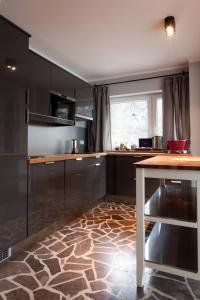 a kitchen with black cabinets and a marble floor at Karolinka Guest House in Szczyrk