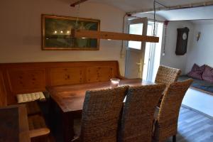 a dining room with a wooden table and chairs at Zimmer Lisa in Förbau