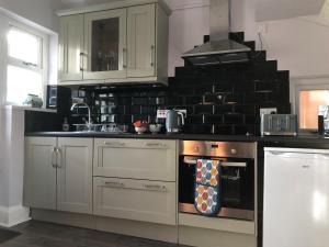 a kitchen with a stove top oven in a kitchen at Coventry Modern House, Private Parking, A45 A46, Sleeps 6, by EMPOWER HOMES in Whitley