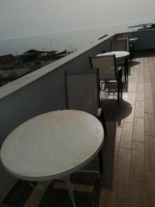 a row of tables and chairs in a room at Crystal Blue Apartments in Nea Kalikratia