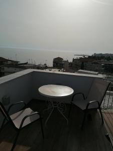 a table and two chairs on a balcony with a view at Crystal Blue Apartments in Nea Kalikratia
