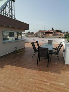 a patio with a table and chairs on a roof at Crystal Blue Apartments in Nea Kalikratia