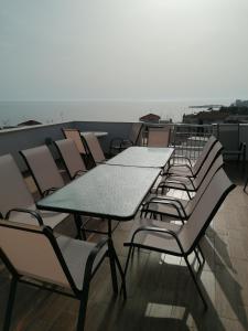 a row of tables and chairs on a roof at Crystal Blue Apartments in Nea Kalikratia