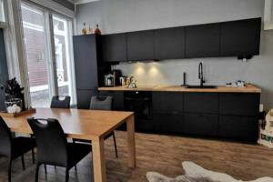 a kitchen with a wooden table and a dining room at Luxury apartment In the middle Of old Rauma in Rauma