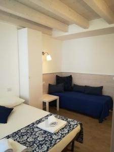 1 Schlafzimmer mit 2 Betten und einem Sofa in der Unterkunft B&B Aria d'Argento - Bike Tours in Trient