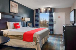 Una habitación de hotel con una cama grande y un televisor. en Capital O 3Y Motel Mount Vernon Renfro Valley, en Mount Vernon