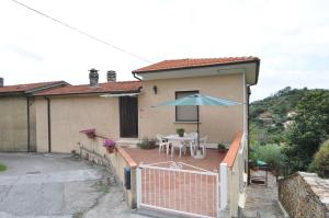een huis met een patio met een tafel en een parasol bij La casa di Silvia in Vallecchia