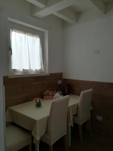 a dining room with a table and chairs and a window at B&B Aria d'Argento - Bike Tours in Trento