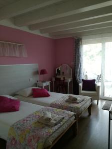 two beds in a room with pink walls at B&B Aria d'Argento - Bike Tours in Trento