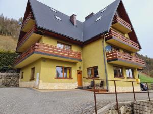 una gran casa amarilla con techo negro en W Zakopanem Hej, en Zakopane