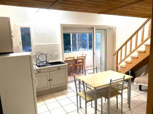 uma cozinha e sala de jantar com mesa e cadeiras em Studio mezzanine St pierre la mer em Fleury