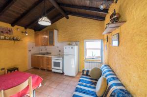een keuken met een bank en een witte koelkast bij Casetta Marì immersa in un vigneto in Dolceacqua