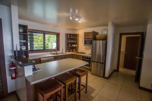 eine Küche mit einem Tisch und einem Kühlschrank in der Unterkunft Rendezvous Villas in Rarotonga