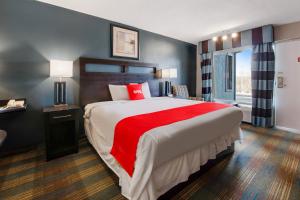 a bedroom with a large bed with a red blanket at Capital O 3Y Motel Mount Vernon Renfro Valley in Mount Vernon