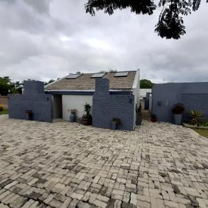 a house with a brick driveway in front of it at Sheilas Self-Catering Overnight Accommodation in Polokwane