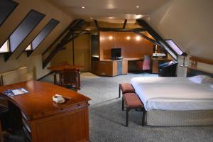 Dormitorio con cama y escritorio en el ático en Fletcher Hotel-Restaurant Kasteel Erenstein, en Kerkrade