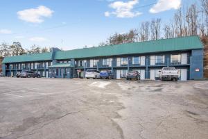 a building with cars parked in a parking lot at Capital O 3Y Motel Mount Vernon Renfro Valley in Mount Vernon
