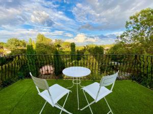 a patio with two chairs and a table on the grass at Le Rez de Jardin Albi in Albi