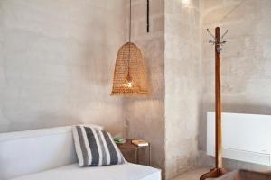 Habitación con sofá blanco y lámpara. en Masseria Pezza, en Salice Salentino